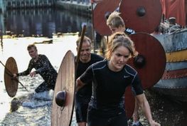 Armed with spears and shields, the trial participants leave the ship by jumping over thegunwale in the forebody of the ship and then run ashore – Fotos: Catherina Sahl. 