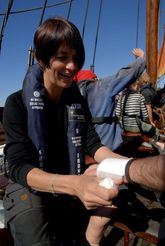 Sygeplejersken Susanne lægger forbinding om håndleddet på et besætningsmedlem. Foto: Werner Karrasch, Vikingeskibsmuseet