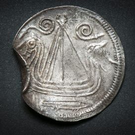 Fra Ottars verden: Nordisk mønt med skibsmotiv. Sandsynligvis slået i Hedeby. Sølv. Ca. 825-30 e.Kr. Vikingeskibsmuseet i Roskilde.