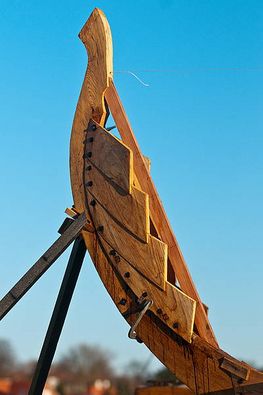 En skibstævn fra skulelevskib, mod den blå himmel over Roskilde Fjord og Vikingeskibsmuseet  