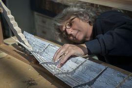 The Viking Ship Museum builds a new reconstruction of a Skuldelev ship. Ship constructor working on a detailed cardbord model of a Skuldelev ship.