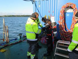 Marie, der er marinarkæolog og uddannet erhvervsdykker, på vej i vandet. Før hvert dyk udføres en fastlagt Sikkerhedsprocedure, hvor dykkerassistenten nøje kontrollerer dykkerens udstyr inden han/hun får lov til at gå i vandet. Foto: Morten Johanse Marie, der er marinarkæolog og uddannet erhvervsdykker, på vej i vandet. Før hvert dyk udføres en fastlagt Sikkerhedsprocedure, hvor dykkerassistenten nøje kontrollerer dykkerens udstyr inden han/hun får lov til at gå i vandet. Foto: Morten Johanse