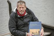 Morten Gøthche sidder i stævnen af en af Vikingeskibsmuseets traditionelle færøbåde med den nye udgivelse