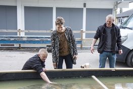 Museum curators and archaeologists Mikkel Thomsen and Morten Johansen look at the big rudder together with Vattenfall's senior geophysicist Dorthe Reng Erbs-Hansen.