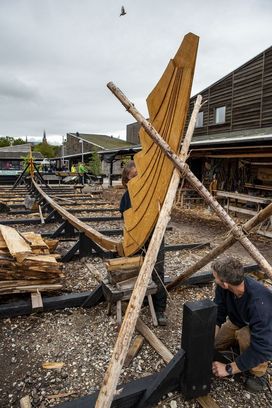 The skilful hands of boatbuilders work quickly to shape the Skuldelev 5's sternpost