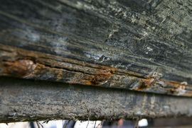The iron rivets expand as they rust, causing cracks along the overlap in the planking.