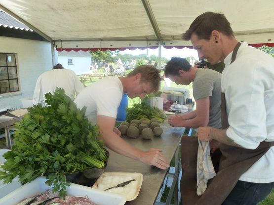 Friske selleri pakkes ind i ler, inden de lægges i bål i flere timer. Steven Lamb fra River Cottage (tv.), Kasper Gaard, Ilse Made (th.) og Gill Meller (bagerst).