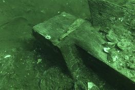 Den halve 'skørnagle', der oprindeligt hat tætnet  samlingen mellem skibets køl og forstævn. Arkæologerne har kun fundet den nederste halvdel af skørnaglen, der sidder på sin plads i lasken på kølen. 