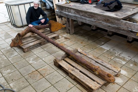 Leder af Marinarkæologisk sektion, Jørgen Dencker, siddende ved ankeret, som nu befinder sig på Vikingeskibsmuseet. Foto Werner Karrasch, Vikingeskibsmuseet
