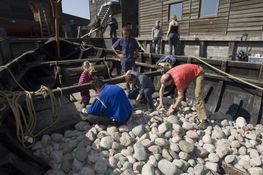 Der skal mange ton ballaststen i et vikingeskib. Her det det Ottar, det store handelsskib, der fyldes.