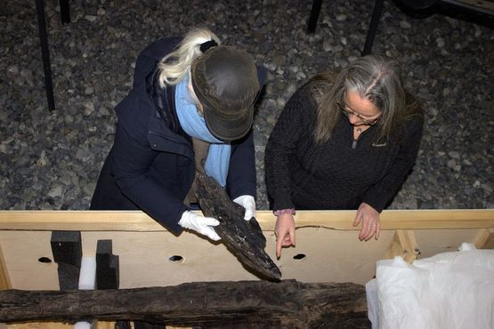 Samlingsansvarlig på Vikingeskibsmuseet Anne C Sørensen og dendroarkæolog  Aoife Daly udvælger de dele af bronzealderbåden, der skal undersøges nærmere.. Copyright Vikingeskibsmuseet i Roskilde.