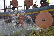 Armed with spears and shields, the trial participants leave the ship by jumping over thegunwale in the forebody of the ship and then run ashore – Fotos: Catherina Sahl. 