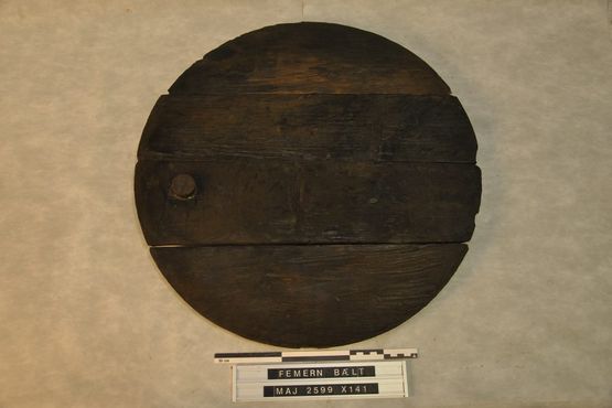 Tøndelåget fra den store tønde lå trykket en smule ned i tønden. Inde i tønden har vi taget prøver af indholdet til senere analyse. Foto: Morten Johansen, Vikingeskibsmuseet. Tøndelåget fra den store tønde lå trykket en smule ned i tønden. Inde i tønden har vi taget prøver af indholdet til senere analyse. Foto: Morten Johansen, Vikingeskibsmuseet.