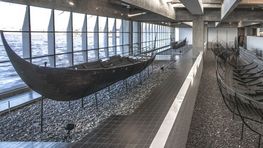 De to vikingefragtskibe Skuldelev 1 og Skuldelev 3 inde i Vikingeskibshallen. 
