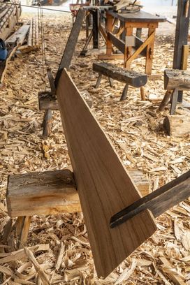 Under the boatyard's canopy, the fresh wood shavings fill the air