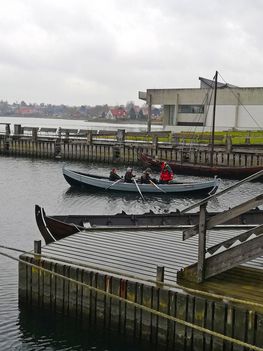 Båden Krákan er klar, og de sætter årerne i vandet, og ror ud fra havnen. Der er et par forhindringer, inden de kommer ud på det rigtige hav: De skal ro uden om fortøjningspæle og under broen, der går over Museumshavnen, og hver gang passe på at årerne ikke rammer.