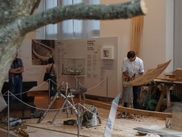 Bådebygger Mike Riebort arbejder midt i udstillingen. Her tildanner han stævnen til det lille vikingeskib. Foto: Jens Müller
