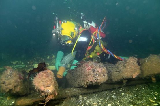 Marinarkæolog Andreas Bloch suger Svælget 1-skibet fri for sand og sediment. Skibet ligger ud af Amagers kyst, og er dateret til ca. 1800. Foto: Morten Johansen