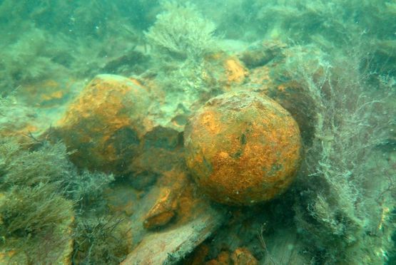 Kanonkugler fundet sammen med det forkullede skibsvrag. Fotoet er taget af marinarkæologerne ved forundersøgelsen af skibsvraget.