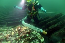Marinarkæologerne suger dynd og sand bort fra skibsvraget Svælget 1-skibet,  Marinarkæolog: Andreas Bloch.  Foto Morten Johansen.