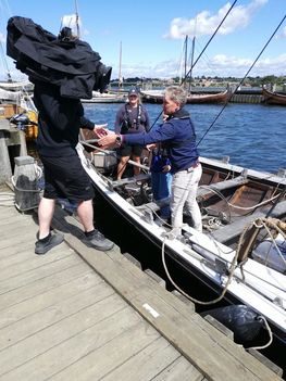 Kameramand fra DR's Vores Vejr kommer ombord på 'Storkjoven'. Det er altid et stort udstyrsstykke, når der skal TV-hold med ud at sejle.