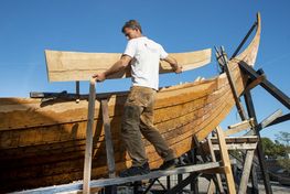 Museets erfarne bådebyggere arbejder på et nyt vikingeskib. 