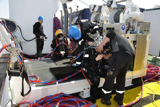 Torsdag d. 3/5: Den 17 kg tunge hjelm sættes på Athena af 2 dykkerassistenter. Foto: Morten Johansen