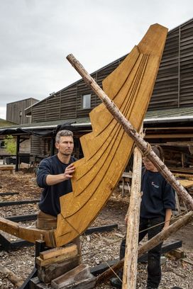 The skilful hands of boatbuilders work quickly to shape the Skuldelev 5's sternpost
