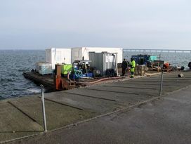 Dykkerflåden på 10x18 meter er tilrigget med skurvogn, dykkercontainer, generator mv. Herfra arbejder marinarkæologerne. Foto: Jørgen Dencker