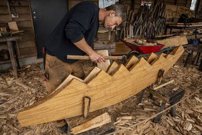 Our skilled boatbuilders are always ready to talk about their work. Here, boat builder Martin works on the sternpost of the Skuldelev 5