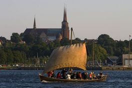 Sejl ud på Roskilde Fjord og oplev det særlige lys når solen går på hæld over Roskilde by set fra vandsiden. Copyright: Vikingeskibsmuseet